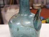 a blue glass vase sitting on a table in a room