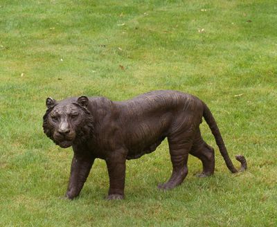 une statue de lion qui se dresse dans l'herbe
