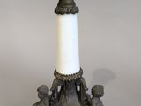 a small candle holder with a white candle on top of it