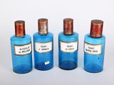 trois bouteilles bleues, munies d'étiquettes, posées les unes à côté des autres