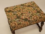a small foot stool with a floral upholstered seat