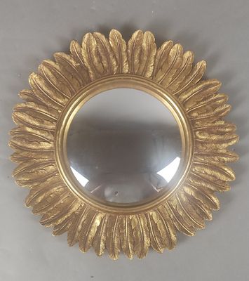 un miroir rond orné d'un motif à la feuille d'or
