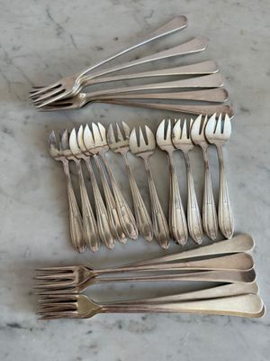 de nombreuses fourchettes et cuillères disposées sur la table