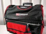 an image of a red and black bag sitting on top of a white table