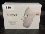 une boîte sur laquelle est représenté un masque blanc, posée sur une table