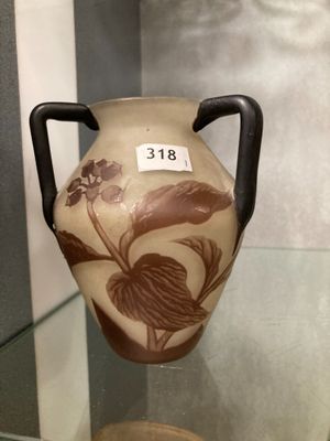 a vase on display in a glass case with a tag on it