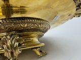 a large gold bowl with a handle on a stand