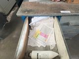 a drawer that has a bottle and papers in it