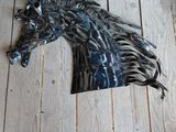 a horse head made out of metal on a wooden floor