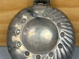 a silver metal object on a blue cloth