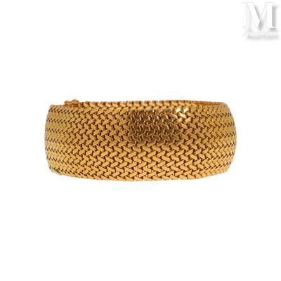 gros plan d'un bracelet en or sur fond blanc
