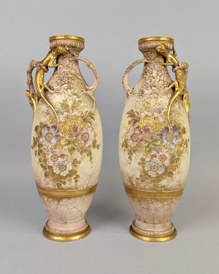 une paire de vases anciens ornés de motifs floraux sur fond gris