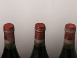four bottles of wine are lined up on a table