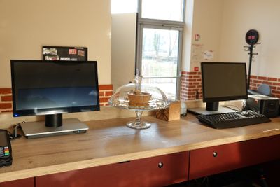 un bureau sur lequel se trouvent deux ordinateurs et une imprimante
