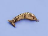 an image of a gold plated fish charm on a blue background