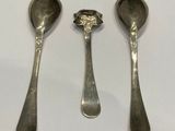 three spoons that are sitting on a table