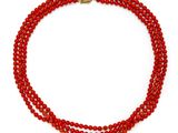 a red beaded necklace with a gold clasp on a white background
