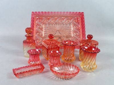 de nombreux objets en verre rose posés sur la table