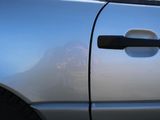 a dog that is sitting in the door of a car