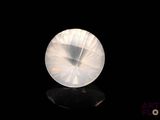 an image of a white crystal stone on a black surface