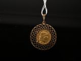 a close up of a gold coin on a white string