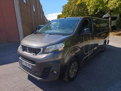 une camionnette grise garée sur le bord de la route, devant un immeuble