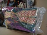 a person holding a bag full of dolls in a box