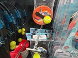de nombreuses raquettes et balles de tennis exposées dans un magasin