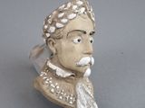une petite statue représentant un homme coiffé d'une couronne