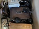 une boîte remplie de vieux téléphones et d'autres appareils électroniques
