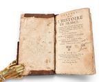an old book with a golden hand resting on top of it