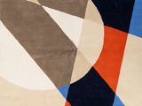 une image représentant un tapis aux motifs géométriques dans les tons de bleu, d'orange et de noir