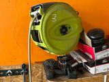 a green blower sitting on top of a table next to a pair of shoes