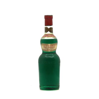 une bouteille d'alcool vert ornée d'un nœud papillon sur le goulot