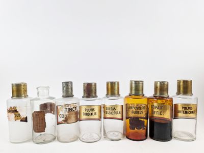 several bottles of different types of alcohol are lined up on a white surface
