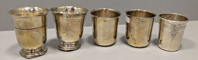 quatre tasses en argent sont alignées sur une table