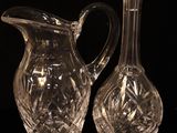 two clear glass vases sitting on top of a black table