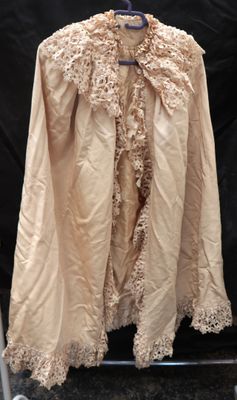 un manteau beige orné de dentelle sur fond noir