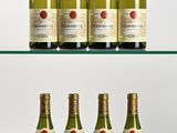 several bottles of wine sit on a glass shelf in front of a white background