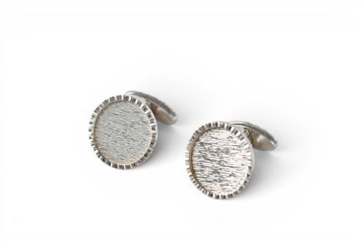 a pair of silver cufflinks on a white background