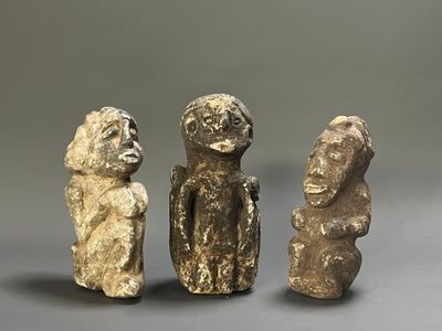 three stone figurines of a man and a woman