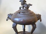 an antique bronze incense burner with a bird on top of it