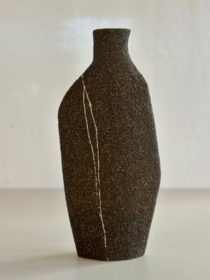 un vase noir orné d'une ligne blanche