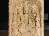 a stone block with a carving of a buddha and other figures