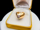 a gold ring with a diamond in it in a yellow box