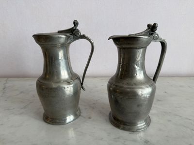 deux vases en argent posés sur une table en marbre