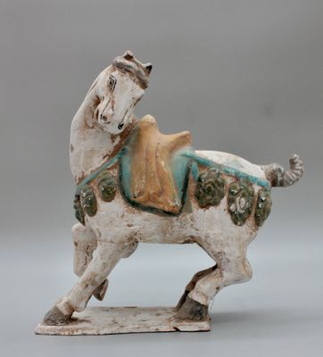 statue d'un cheval avec une selle sur le dos