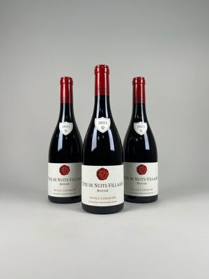 trois bouteilles de vin rouge posées sur une table