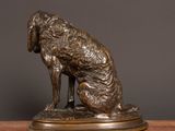 bronze statue of a dog sitting on a wooden table
