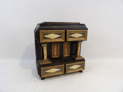 une petite commode en bois à quatre tiroirs